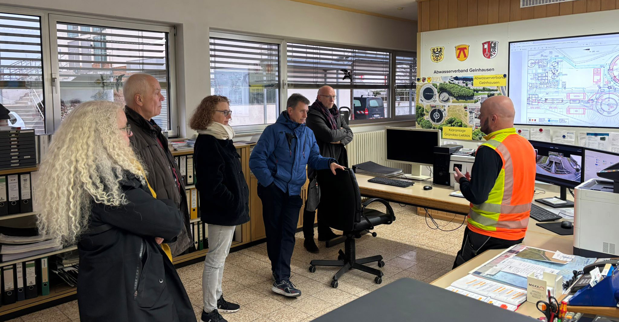 Kai Geiger erläutert Michael Bollmann, Erhard Hartmann, Astrid Rost, Albert Ungermann und Martina Wolf-Eisenberg (von rechts) die Ausbaupläne. 2026 Besichtigung Klaeranlage